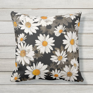 Weißes Gänseblümchen-Blumen auf Schwarzem Kissen