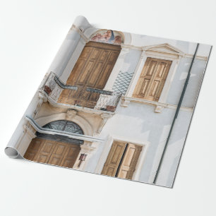 WEISSES, KONKRETES GEBÄUDE MIT HOLZTÜREN UND WIND GESCHENKPAPIER