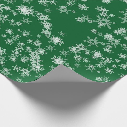 Weißes Schneeflocken auf grünem Umschlagpapier Geschenkpapier (Ecke)