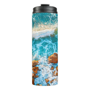 Wellen auf einem felsigen Strand bei Sonnenunterga Thermosbecher