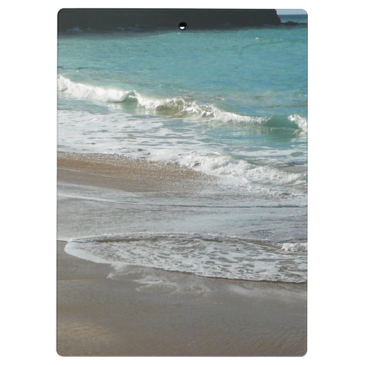 Wellen, die sich am türkisblauen Meer am Strand sa Klemmbrett