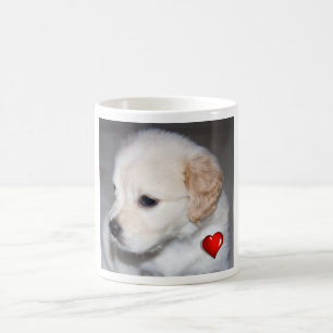 Welpe des goldenen Retrievers mit einer roten Kaffeetasse