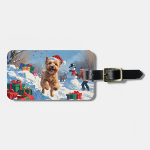 Wheaten Terrier läuft im Schnee mit Weihnachtsmütz Gepäckanhänger