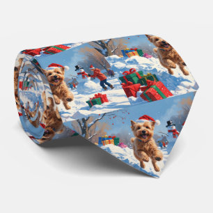 Wheaten Terrier läuft im Schnee mit Weihnachtsmütz Krawatte