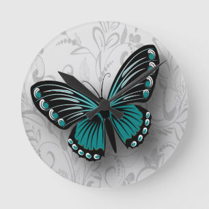 Whimsicaler Teal-Schmetterling auf grauer Blütenpr Runde Wanduhr