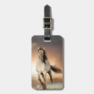 Wilder Stallion, der in Sonnenuntergang läuft Gepäckanhänger