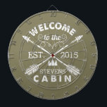 Willkommen in der Hütte | Rustikale Pfeile Persona Dartscheibe<br><div class="desc">Verbringen Sie erholsame Stunden mit diesem lustigen,  einzigartigen Dartboard. Das Design hat einen olivgrünen Hintergrund mit "Welcome to the [Name] Cabin" in rustikalem Blocktext und zwei gekreuzten Pfeilen. Passen Sie Ihren Familiennamen und das Jahr an,  in dem Sie sich befinden. Macht ein phantastisches Hauswärmespiele oder Geschenk für Ihre Wochenendwirte!</div>