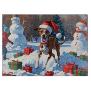 Windhund läuft im Schnee mit Weihnachtsmütze Schneidebrett