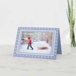 Winterwunderland mit Junge und seinem Schlitten Karte