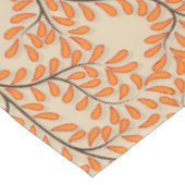 Wirbelnde orangefarbene Blätter auf beigem Hinterg Tischdecke (Schrägansicht)