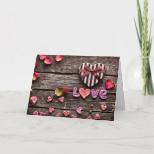 Wort Liebe mit herzförmigem Valentinstag-Geschenk Feiertagskarte