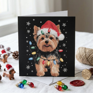 Yorkie-Weihnachtshund mit Weihnachtsmannmütze und Feiertagskarte