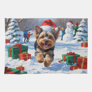 Yorkipoo läuft im Schnee mit Weihnachtsmütze Geschirrtuch