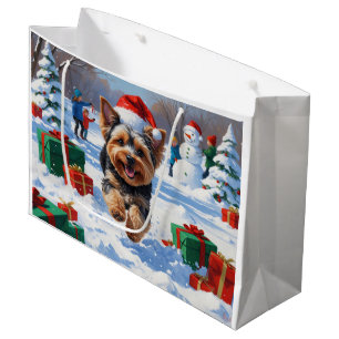 Yorkipoo läuft im Schnee mit Weihnachtsmütze Große Geschenktüte