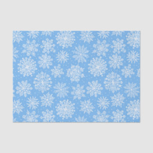 Zarte weiße Schneeflocken auf einem hellblauen Hin Seidenpapier