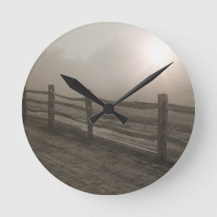 Zaun und Sonnendurchbruch durch Nebel nahe Sharon Runde Wanduhr