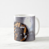Zigaretten-Hintern im silbernen Kaffeetasse (VorderseiteRechts)