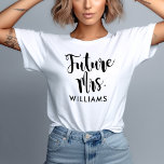 Zukünftige Frau Black Script Custom Nachname Weddi T-Shirt<br><div class="desc">Moderne Hochzeitsgestaltung "Future Mrs." mit eigenem Shirt für die Braut mit einem modernen Schwarz-Weiß-Farbschema mit fett- und spielerisch handgeschriebener Kalligraphie-Schrift-Typografie mit stilvollen Schriftzügen. Personalisieren Sie den lässigen und dennoch eleganten Text ihren neuen / zukünftigen verheirateten Nachnamen.</div>