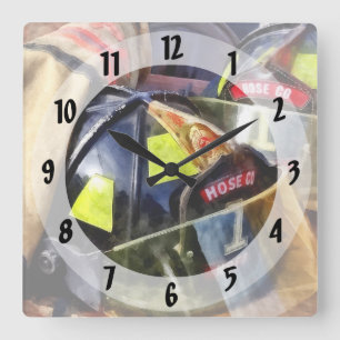 Zwei Feuerhelme und Feuerwehrmäntel Quadratische Wanduhr