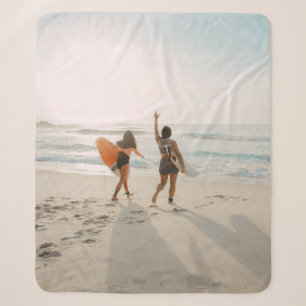 Zwei Frauen, die zum Ozean laufen und surfen Sherpadecke