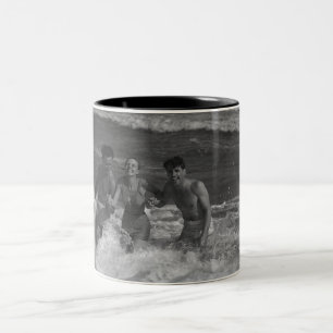 Zwei junge Männer und Frau, die in der Welle B&W Zweifarbige Tasse