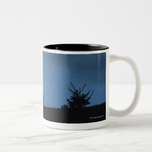 Zwei Kühe in der Silhouette weiden lassend auf Zweifarbige Tasse