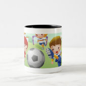 Zwei Mädchen und ein Junge, der Fußball spielt Zweifarbige Tasse (Mittel)