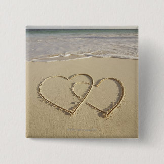 Zwei Oberherzen, die am Strand gezeichnet werden Button