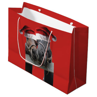 Zwei Pferde Küssen mit dem Weihnachtsmann Hats auf Große Geschenktüte