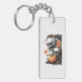 Zwei Schädel und ein Kürbis unter den Blume. Schlüsselanhänger (Vorderseite links)