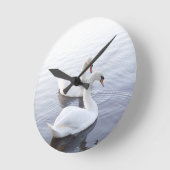 Zwei Schwäne schwimmen am ruhigen See Runde Wanduhr (Winkel)