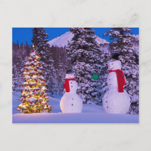 Zwei Snowmen tauschen Geschenke vom Baum Feiertagspostkarte