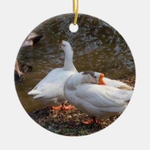 zwei weiße Gänse spielen an einem Teich. Keramikornament
