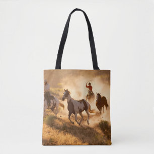 Zwei Western Cowboys reiten Pferde und springen wi Tasche