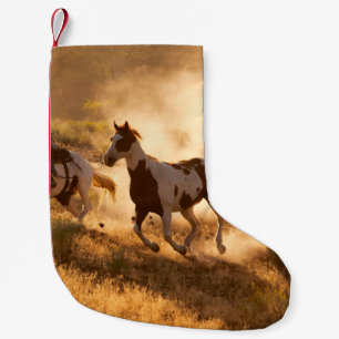 Zwei westliche Cowboys reiten Pferde und werfen wi Kleiner Weihnachtsstrumpf