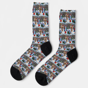 Zwergspitz läuft im Schnee mit Weihnachtsmütze Socken