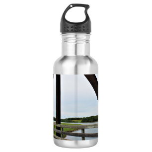 Zwischen den Stangen des Rosts Edelstahlflasche