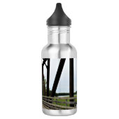 Zwischen den Stangen des Rosts Edelstahlflasche (Links)